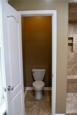 A private toilet area, conveniently located within a bathroom, features practical tile flooring.