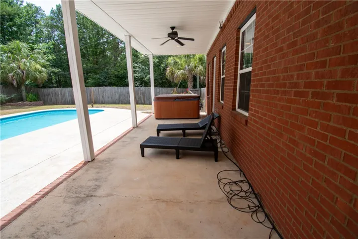 A spacious covered patio provides a delightful outdoor living area overlooking the swimming pool and hot tub.