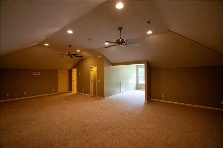 A spacious recreation room offers comfortable carpeting and dual ceiling fans for year-round enjoyment.