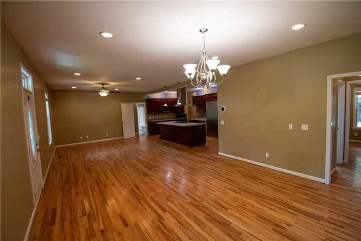 An open floorplan with hardwood flooring seamlessly connects the living space to the chef's kitchen.