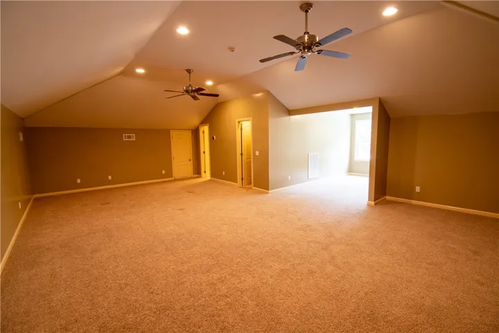 A spacious bonus room features sloped ceilings and ample lighting for diverse uses.