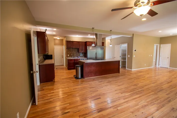 A chef's kitchen with a generous island opens to living space, featuring gleaming hardwood floors.