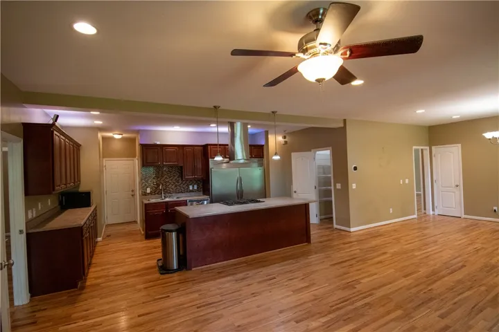 An open concept kitchen flows seamlessly into the living area, featuring rich cabinetry and a central island.