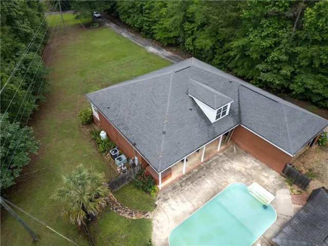 An aerial perspective reveals a private pool complementing this classic brick-built home.