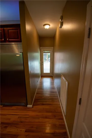 A gleaming hardwood floor stretches towards a bright glass-paned door.