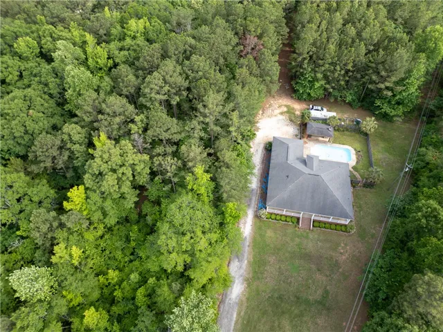 Escape to this private woodland retreat featuring a sparkling pool and mature landscaping.