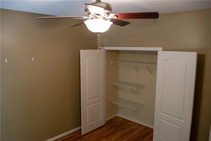 A comfortable bedroom with rich hardwood floors and a spacious closet awaits.