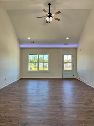 Vaulted ceilings and rich wood-look flooring enhance this inviting, sunlit living area.