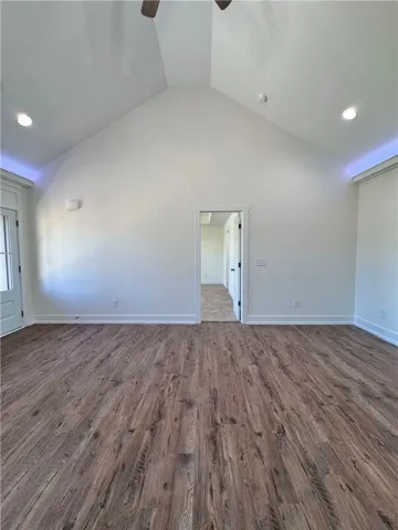 Rich wood flooring anchors this open room, highlighted by a dramatic vaulted ceiling.