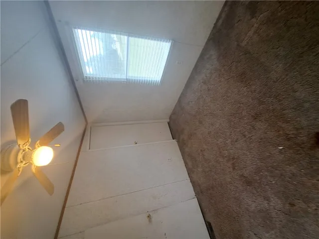 Illuminated by a skylight, this room features a practical ceiling fan for comfort.
