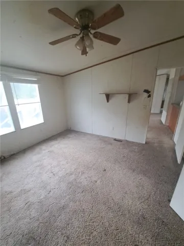 A living space offers wall-to-wall carpeting and ample natural illumination from multiple windows.