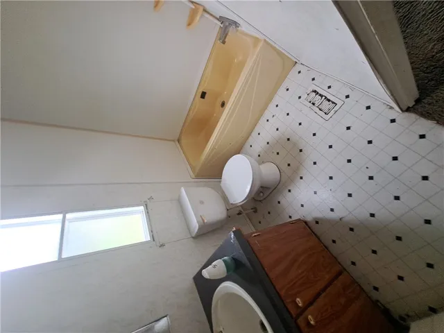 A well-lit bath features a shower/tub combination and a practical vanity with storage.
