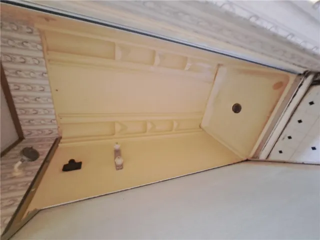 An essential shower stall awaits within this bathroom, ready for daily refreshment.