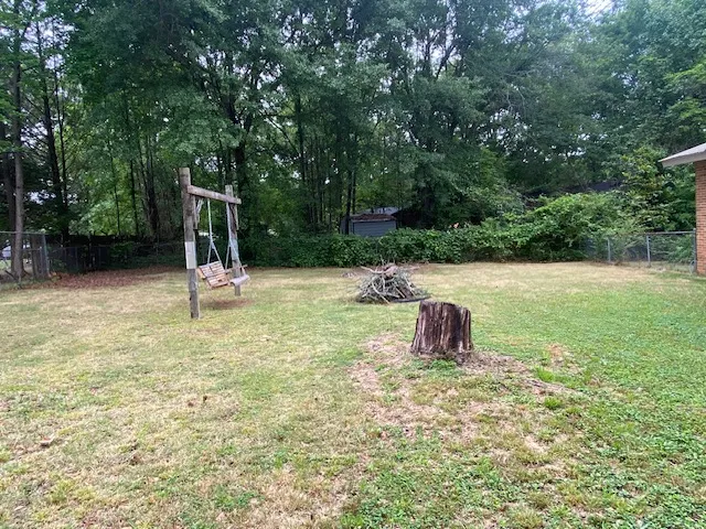 A spacious yard with mature trees and ample room for outdoor activities.