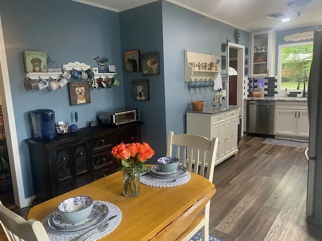A well-appointed kitchen features a dining area, ample cabinetry, and rich wood flooring.
