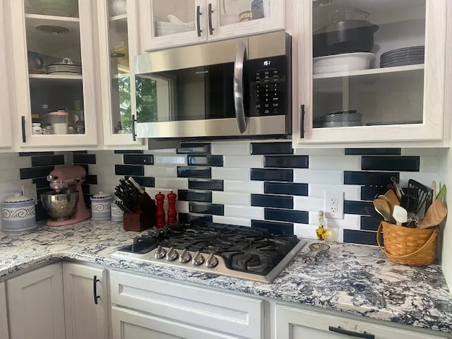 Culinary delights await with a modern gas cooktop set against an eye-catching backsplash.
