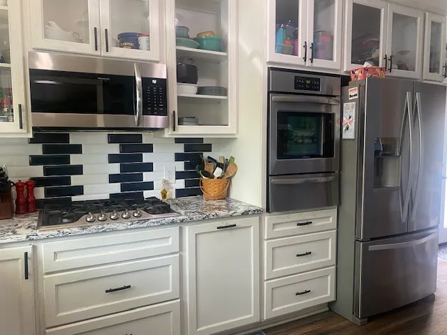 A well-appointed kitchen showcasing contemporary appliances and stylish black and white tile work.