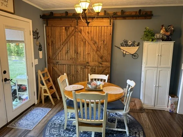 A charming eat-in kitchen with rich wood flooring and a distinctive barn door feature.