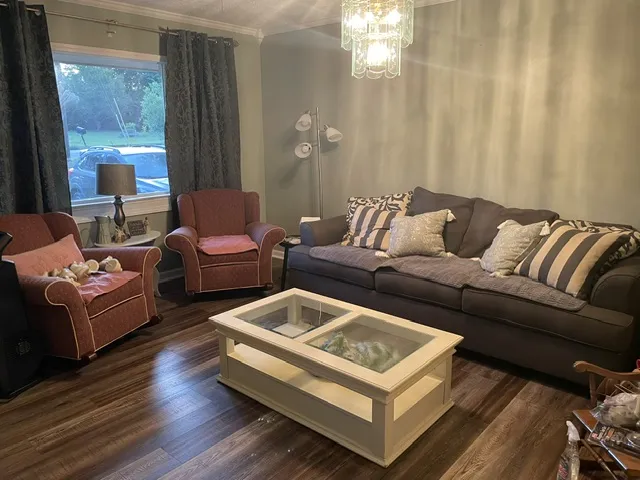 Rich hardwood flooring complements the comfortable seating in this inviting living space.