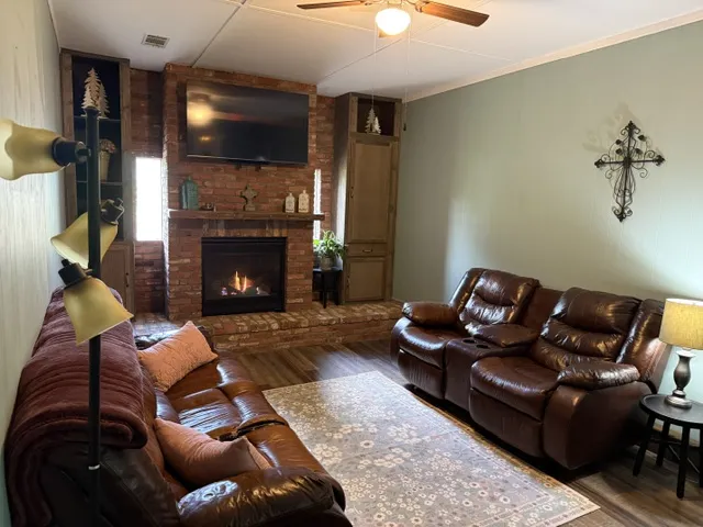 A comforting living room offers a brick fireplace and a warm, inviting atmosphere for relaxation.