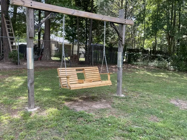An inviting swing set offers a charming spot to unwind in the verdant private yard.
