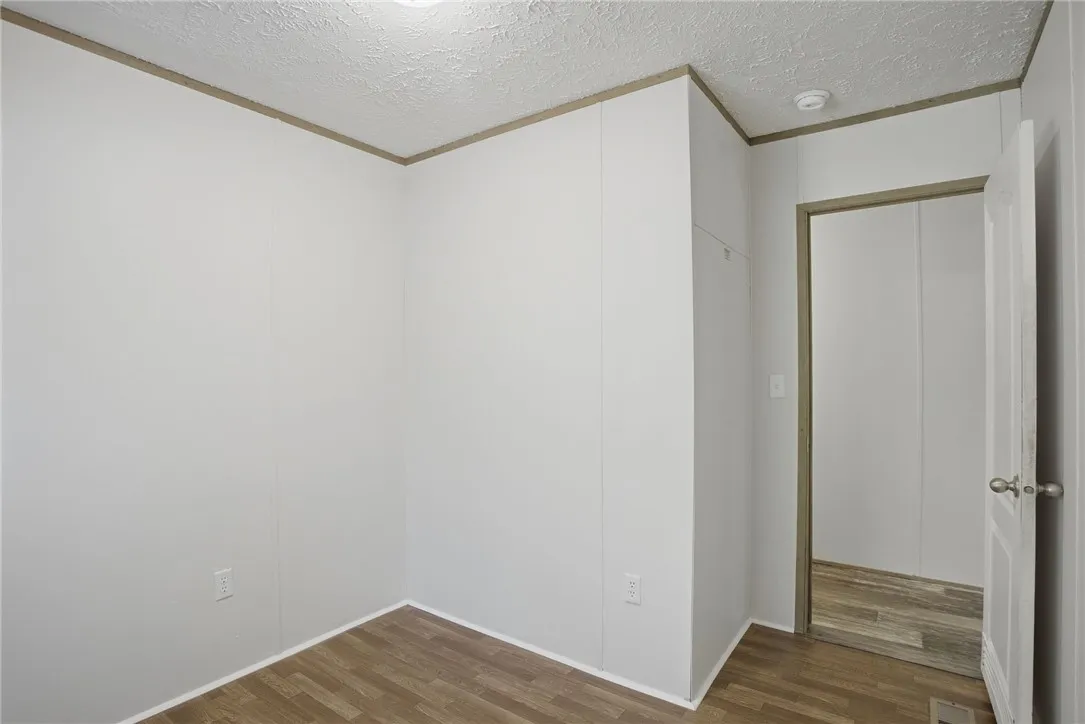 A well-lit, unfurnished room offers flexible living space with durable flooring.