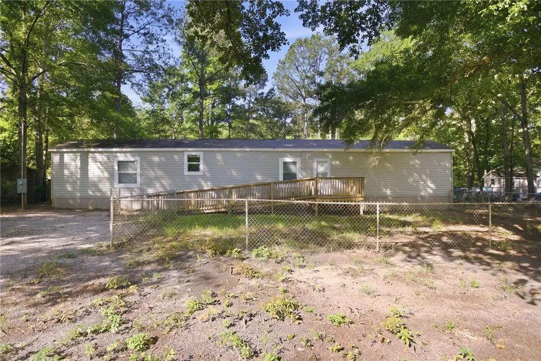 A private, wooded lot surrounds this accessible residence, featuring a welcoming ramp leading to the back entry.