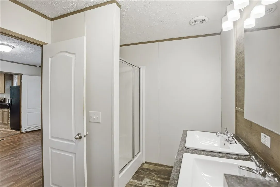 Double vanity sinks and a stand-up shower offer practical elegance in this well-appointed bathroom.