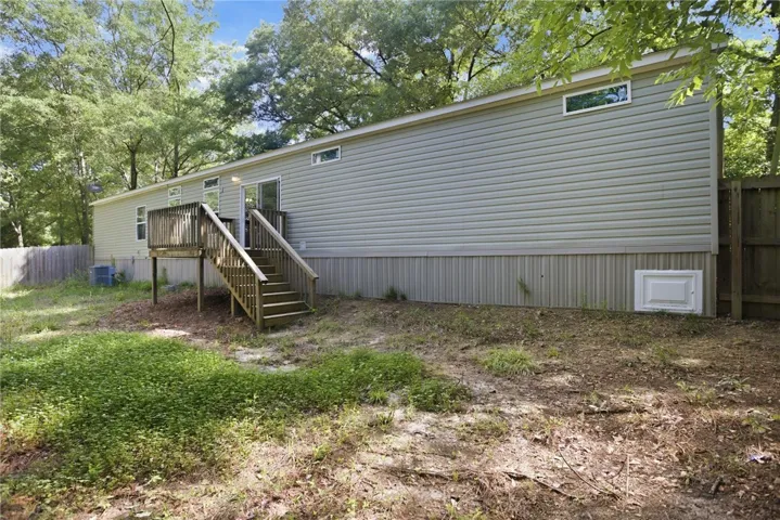 A private backyard oasis awaits, complete with a charming wooden deck and stairs.