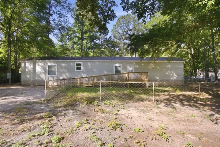 A private, wooded lot surrounds this accessible residence, featuring a welcoming ramp leading to the back entry.