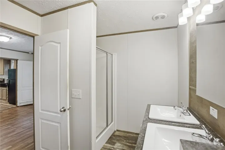 Double vanity sinks and a stand-up shower offer practical elegance in this well-appointed bathroom.