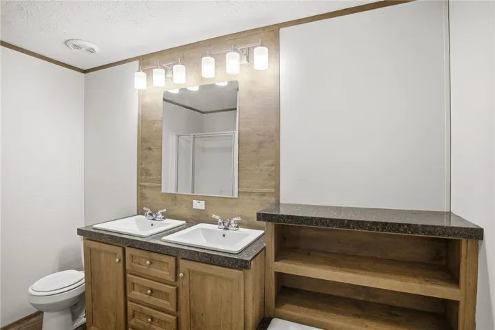 Double vanity with ample storage and stone countertops creates a functional bathroom space.