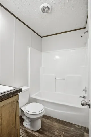 Functional full bathroom featuring wood-look flooring and a combined shower-tub unit.