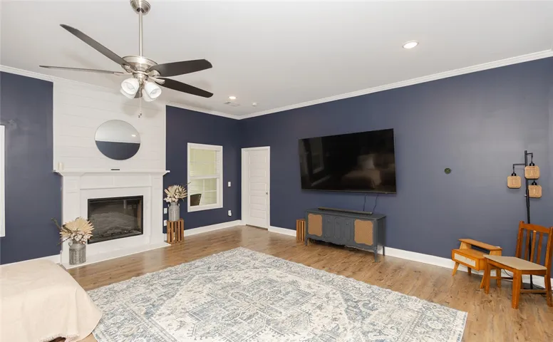 A comforting living area showcasing a refined fireplace with mantle and warm hardwood flooring.