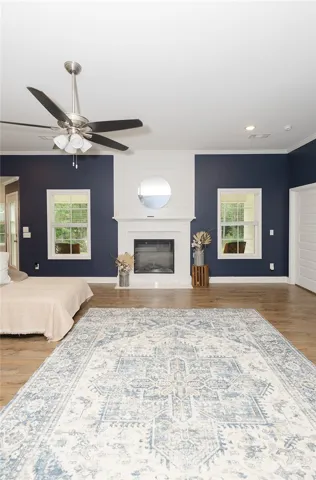 A refined living space showcases rich navy walls, a welcoming fireplace, and polished wood-look flooring.