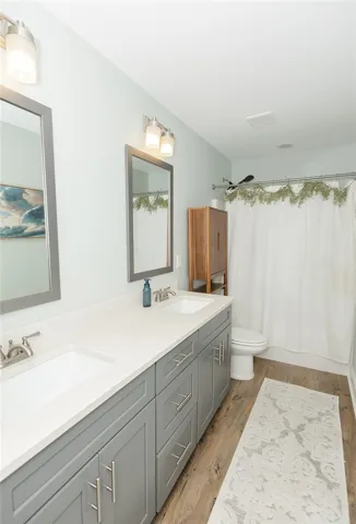 Dual vanities with crisp countertops and sleek gray cabinetry provide ample space.