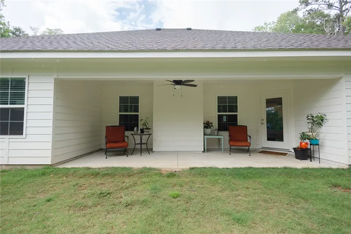 A spacious covered patio invites relaxation with ceiling fan comfort and direct access to the home.