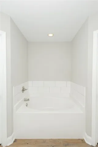 A deep soaking tub awaits in this calm and serene bathing space.