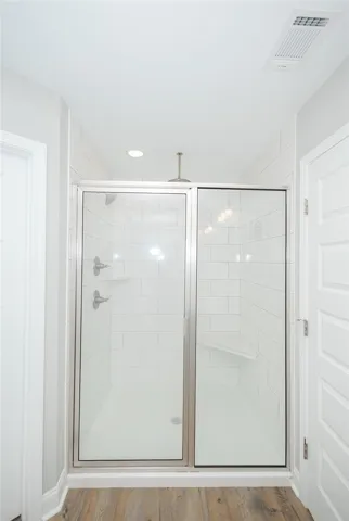 A well-appointed shower stall features white subway tile and a built-in bench, offering both style and utility.