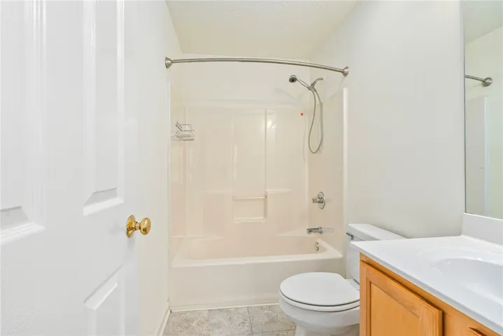 Well-maintained full bathroom featuring a tub and shower combination with a bright vanity area.