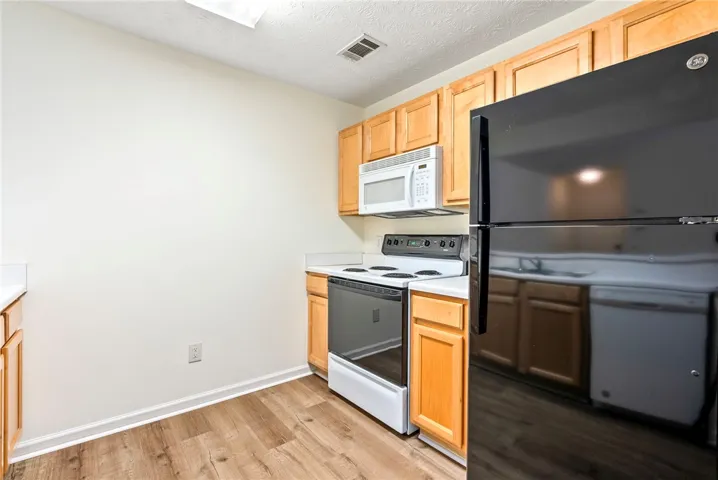 A well-equipped kitchen features a suite of modern appliances and attractive wood-toned cabinetry.