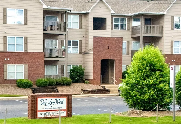Well-maintained grounds frame this appealing multi-story building, featuring inviting balconies and a prominent brick entrance.