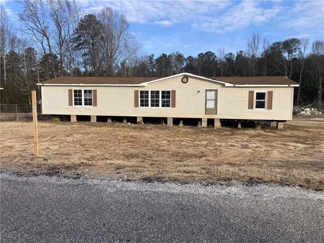 A well-maintained manufactured home awaits on a spacious, open lot, ready for personalization.