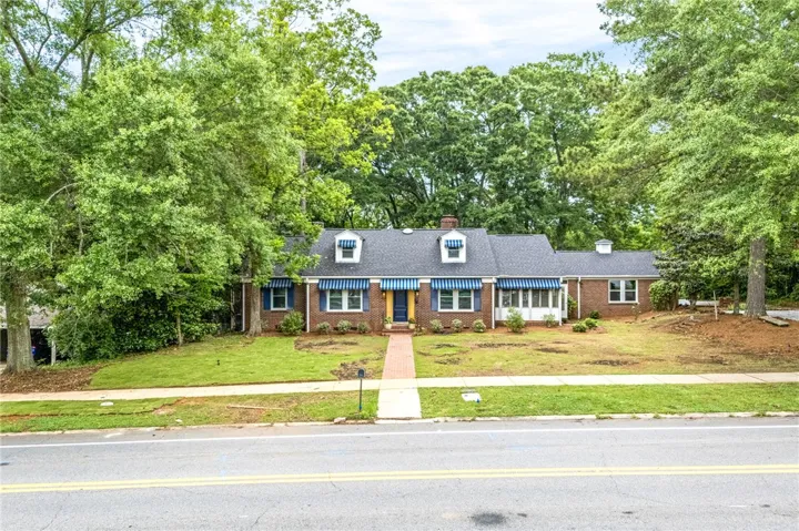 A classic brick facade is adorned with charming striped awnings and a welcoming brick pathway.