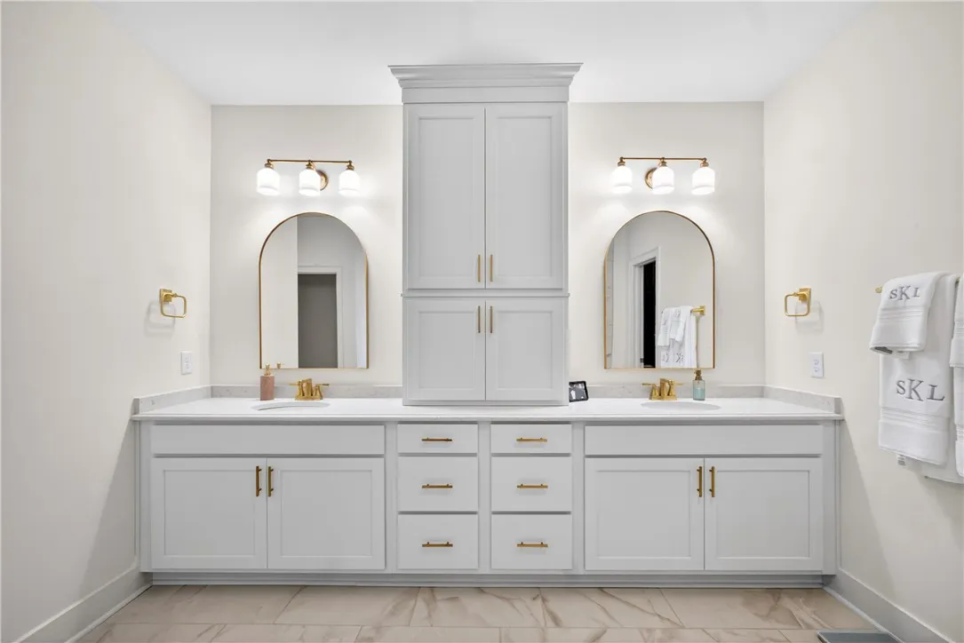 Dual vanity with elegant arched mirrors creates a harmonious primary bath retreat.