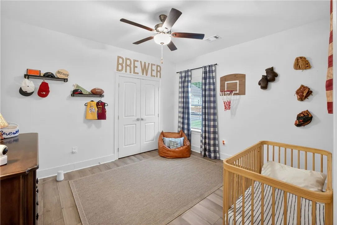 This naturally illuminated bedroom offers LVP flooring and a ceiling fan for comfort.
