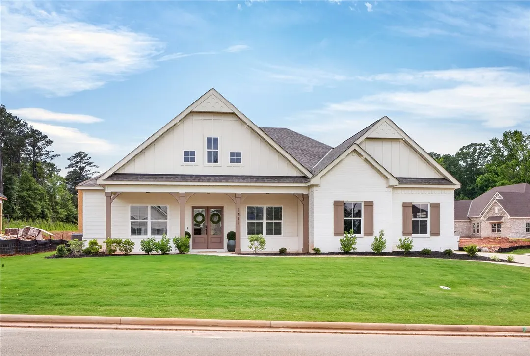 A graceful facade features an inviting covered porch and neat landscaping.
