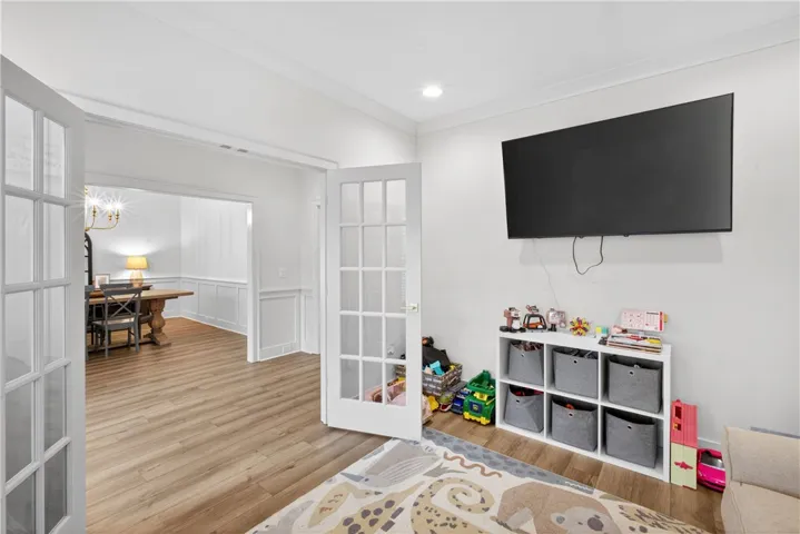 French doors open into a bright room with LVP flooring, perfect for a den or formal dining.