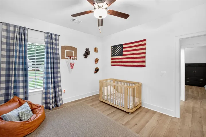 LVP floors and bright windows illuminate this cozy bedroom.