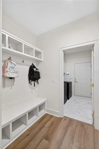 A well-appointed mud room features built-in storage with a convenient bench and overhead shelving.